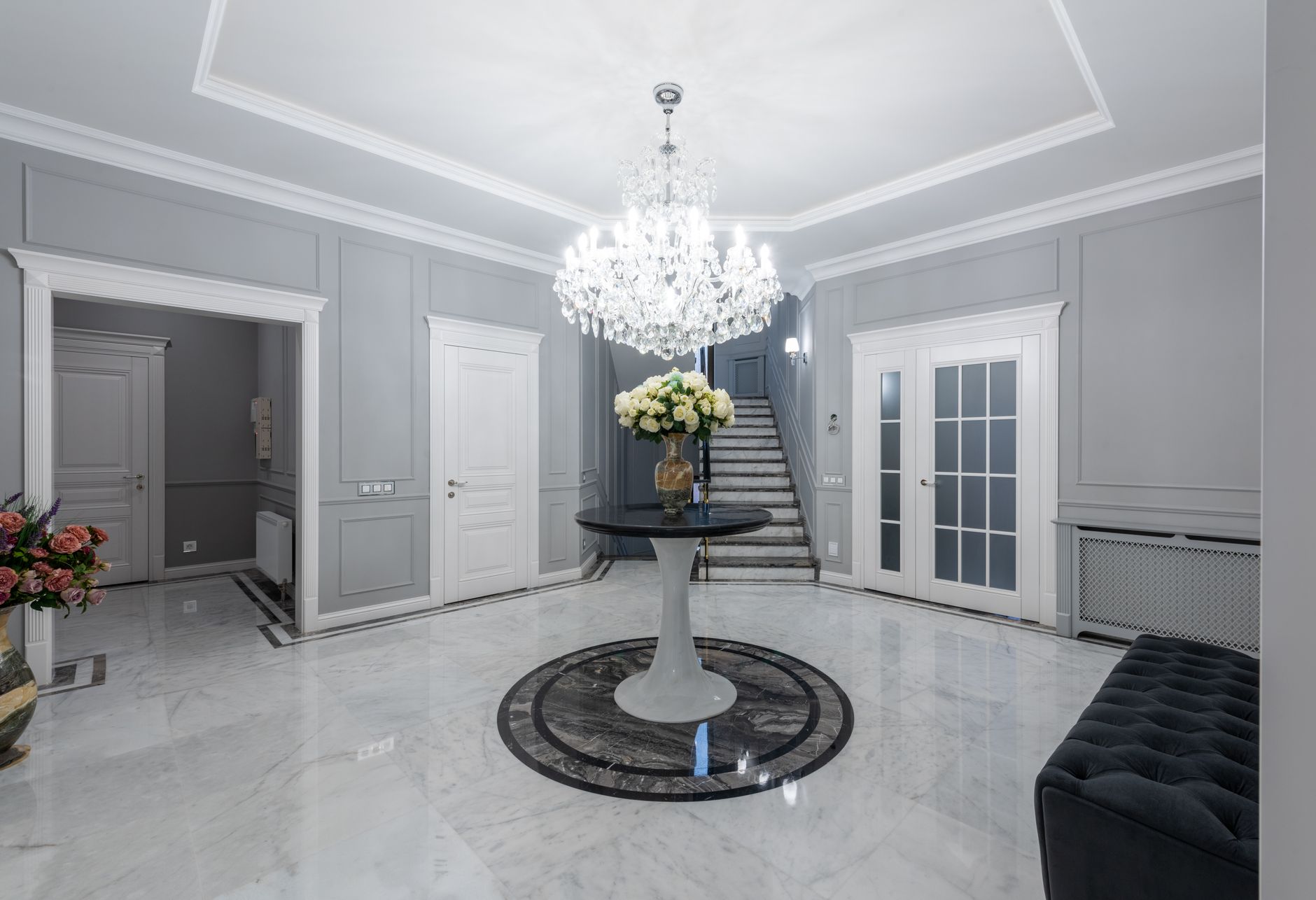 Interior of modern hall with glowing chandelier and soft sofa on sparkling clean floor in Riverside, CA